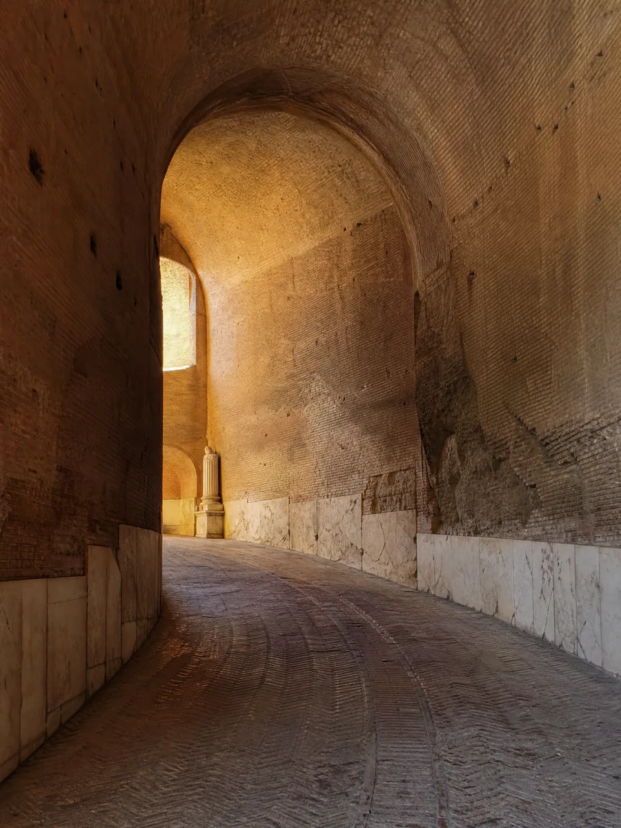 Una rampa a spirale di mattoni antichi illuminata da una luce morbida